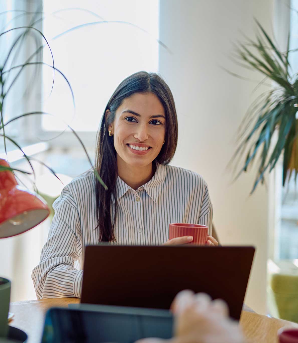 Woman smiling during a meeting with colleagues in a bright modern office