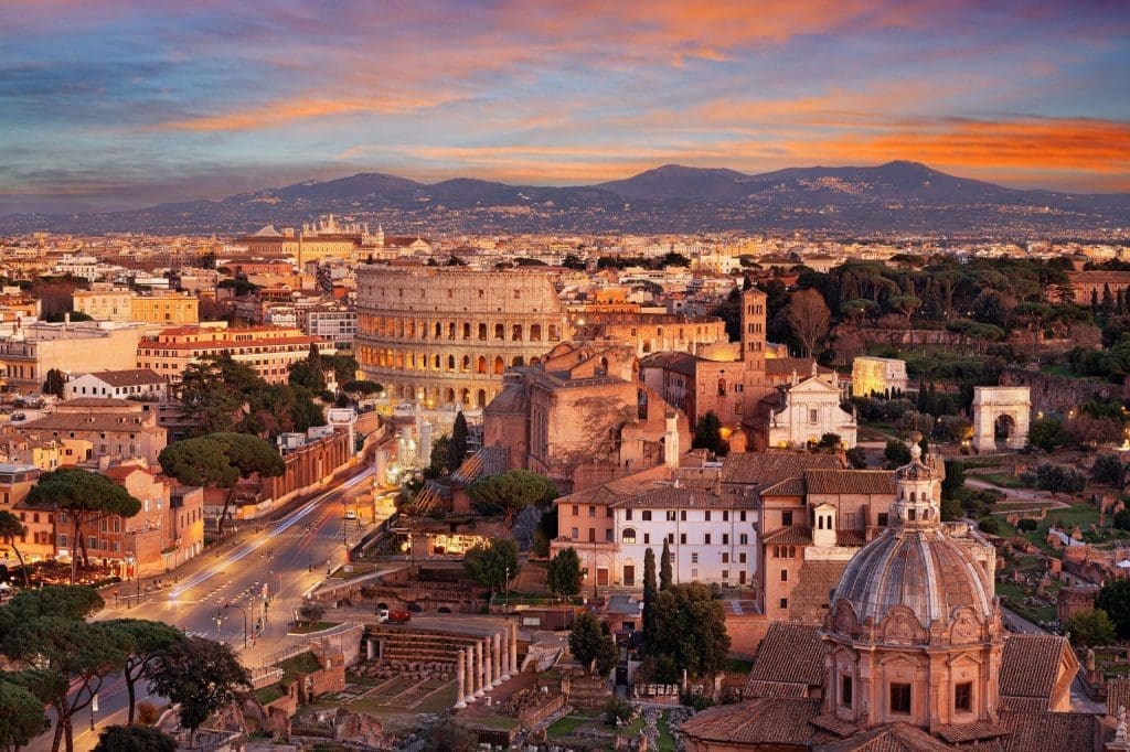 Panoramic view of Rome's historic architecture and skyline at sunset.
